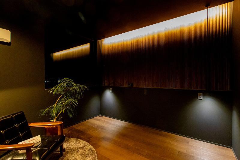 寝室。黒い壁紙と無垢材を組み合わせた落ち着きのある空間に。